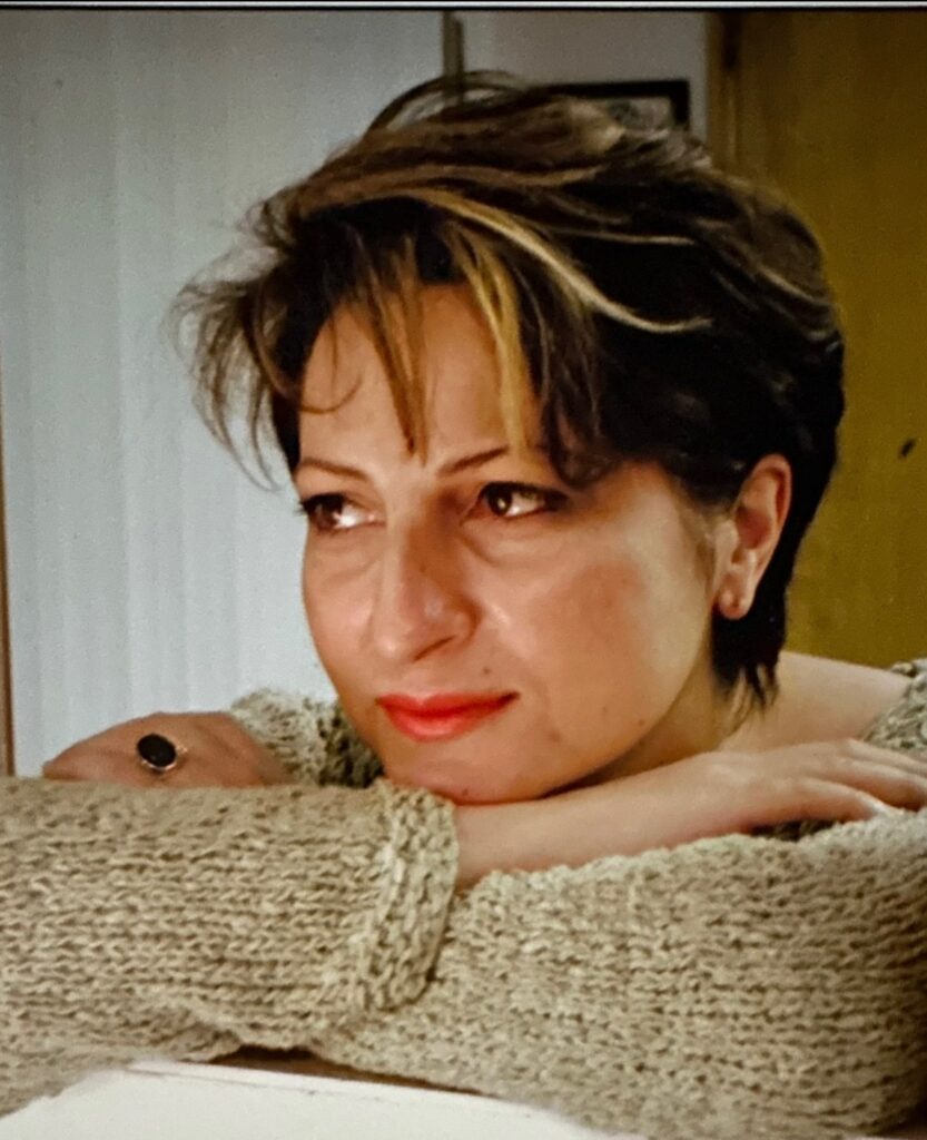 Laura Durgaryan, painter, with thoughtful expression, wearing a cozy sweater, highlighting her artistic warmth and emotional depth.